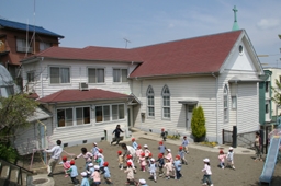 国の登録有形文化財に指定されている日本基督教団横須賀上町教会。付属のめぐみ幼稚園で園児たちが遊んでいる＝同教会提供