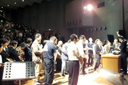 第５回首都圏キリスト教大会最終日、主講師であるサン氏の呼びかけに応えて講壇の前で祈りをささげる会衆＝０６年５月１４日、東京・青山学院講堂で