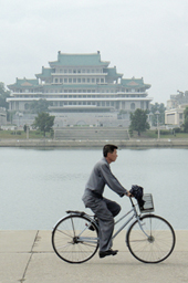 国指定の制服を来て自転車に乗る平壌市民