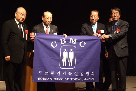 韓国基督実業人会（韓国ＣＢＭＣ）から東京支会へ記念旗が渡された。中左が韓国ＣＢＭＣのキム・スウォン会長、中右が東京支会のオ・ヨンソク会長。
