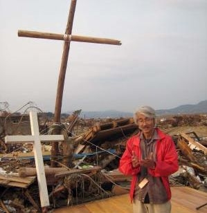 気仙沼第一聖書バプテスト教会跡に立つ二つの十字架と同教会嶺岸浩牧師（写真提供：国際飢餓対策機構）   