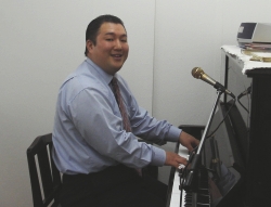 ピアノの腕を披露する新宿福興教会の菅野直基牧師