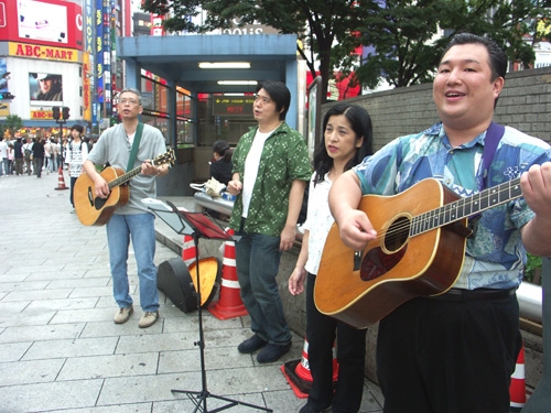 田崎牧師（左端）、菅野牧師（右端）らがJR新宿駅東口前で路傍伝道を行った。(７日、高柳写す)