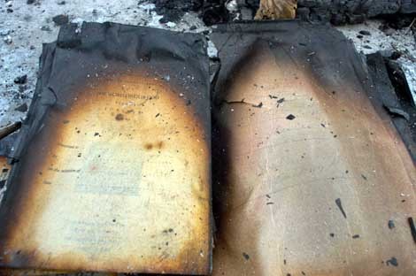 ▲フラッシュに照らされる黒く焼け焦げた聖書 ▲フラッシュに照らされる黒く焼け焦げた聖書