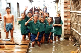 水につかりながら勉強を続ける子どもたち（バングラデシュ・ダッカ市内）写真＝JIFH＝