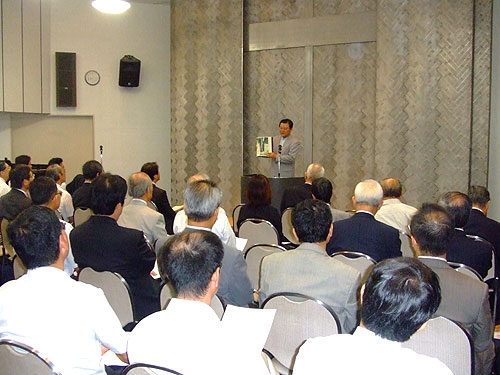 説教中、震災時に虐殺された在日韓国人のための供養碑を紹介するパク・スギル牧師と礼拝出席者たち＝１日、在日韓国ＹＭＣＡで
