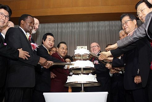  ＷＥＡとＣＣＫの代表者らが感謝祭合同礼拝後にケーキカットセレモニーを行った。中央左がＣＣＫ代表会長のキル・チャヨン氏、中央右はＷＥＡ代表のジェフ・タニクリフ氏。２０１１年１１月１４日、韓国ソウルで。