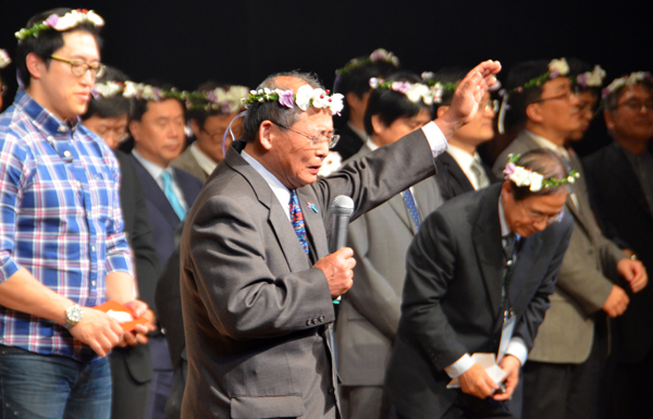 来場者の祝福を祈る大会実行委員長で長野聖書教会牧師の北村喜彦氏（写真中央）＝１６日、長野市のホクト文化ホールで