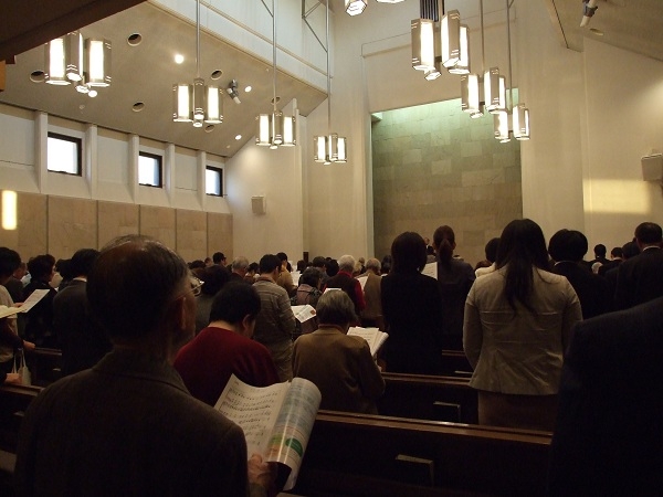 讃美歌「もろびとこぞりて」を賛美する参加者たち＝１５日、東京都千代田区の日本基督教団富士見町教会で