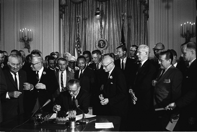  公民権法に署名するリンドン・B・ジョンソン大統領、ジョンソンの真後ろが公民権運動指導者のマーティン・ルーサー・キング・ジュニア牧師