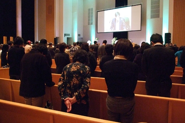 祈祷をささげる参列者たち＝１１日、仙台市の東北学院中高等学校礼拝堂で