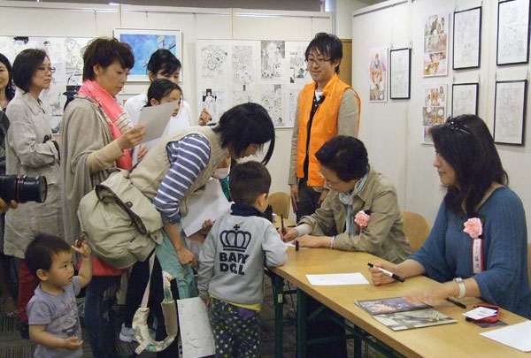 漫画家にサインを求める来場者＝１２日、東京・銀座の教文館で