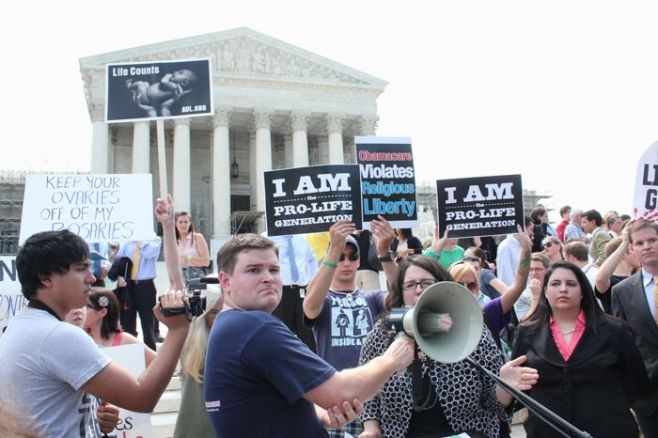  　米最高裁前で医療保険改革法合憲判断に抗議する妊娠中絶反対派の活動家らの様子。２０１２年６月２８日（写真提供：米ＣＰ） 