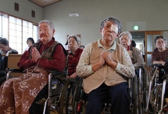 祈りを捧げる被ばく高齢者ら（©2011 SUPERSAURUS）
